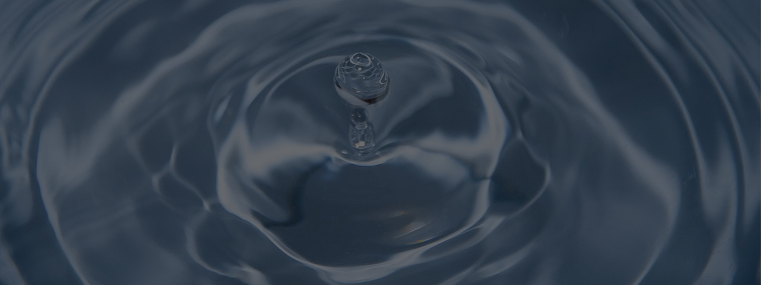 Water ripples with a droplet at the center.