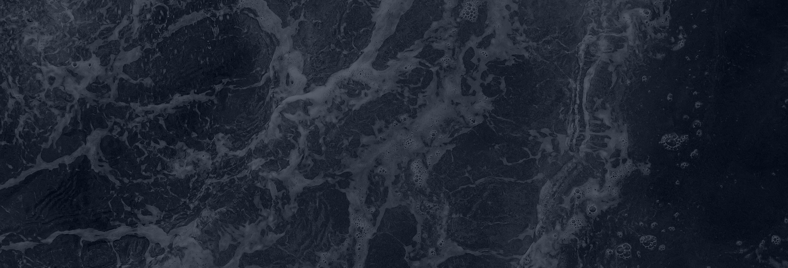 Water droplet creating ripples in dark background