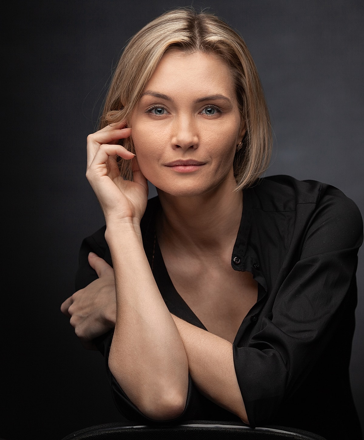 Woman in black shirt, thoughtful expression.