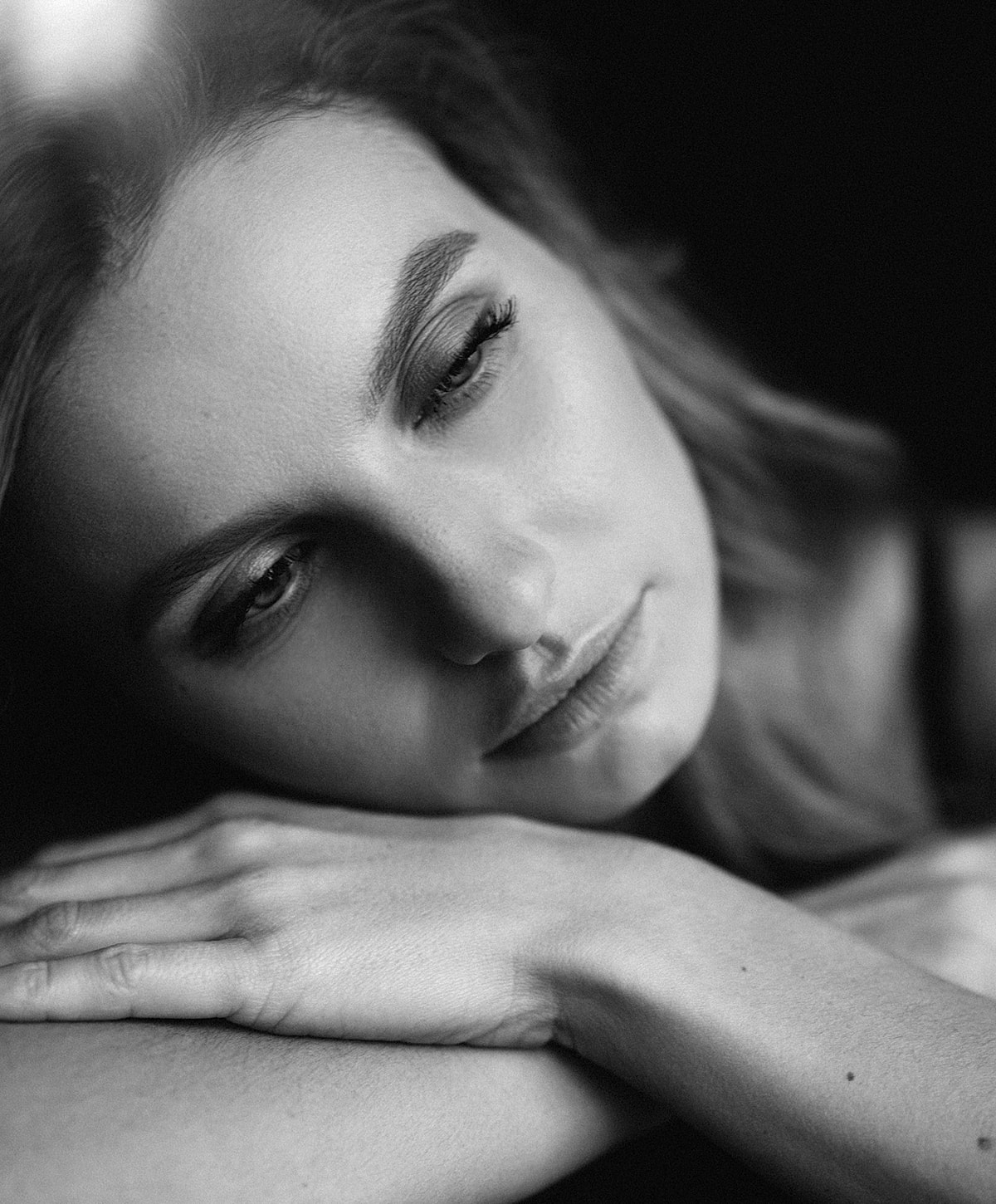 Thoughtful woman resting her chin on hands.