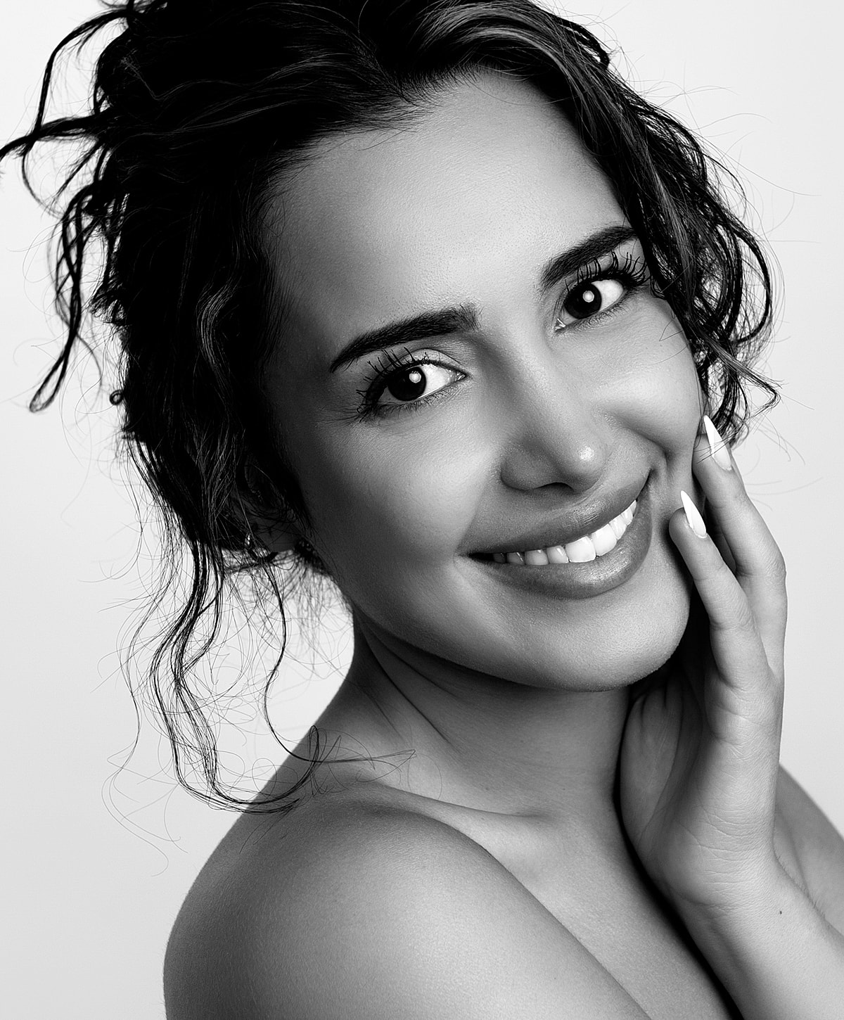Smiling woman with curly hair in black and white.