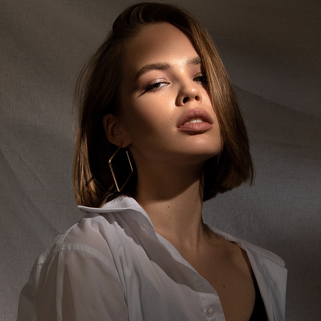 Portrait of woman with stylish haircut and earrings.