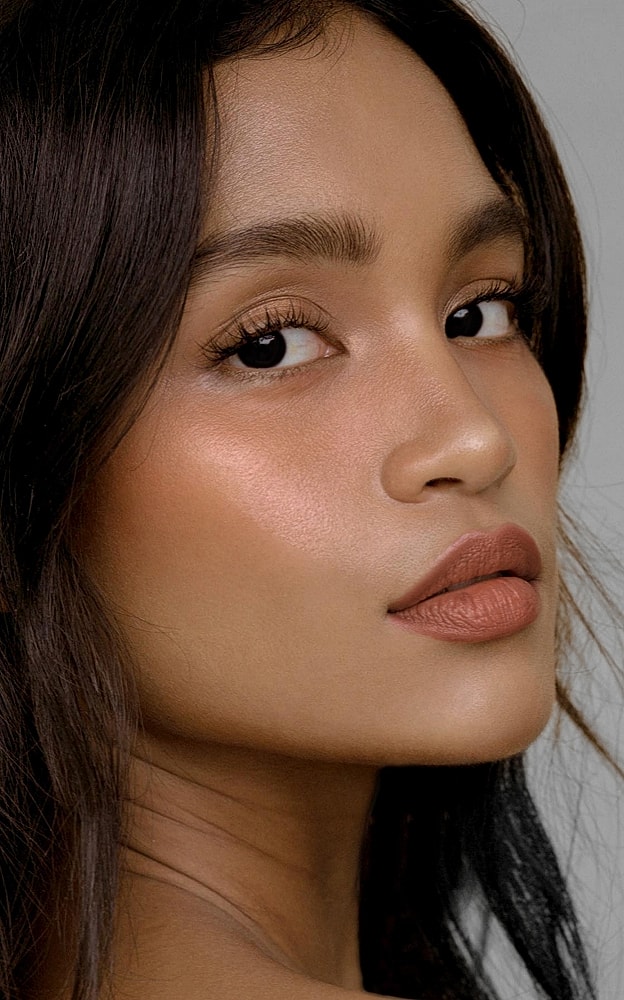 Model with natural makeup, side profile shot.