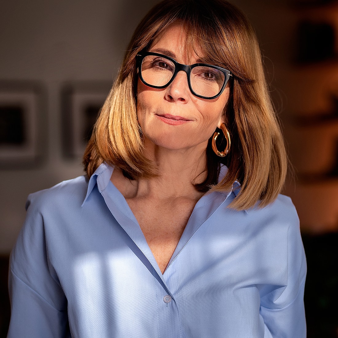 Woman with glasses in light blue shirt.