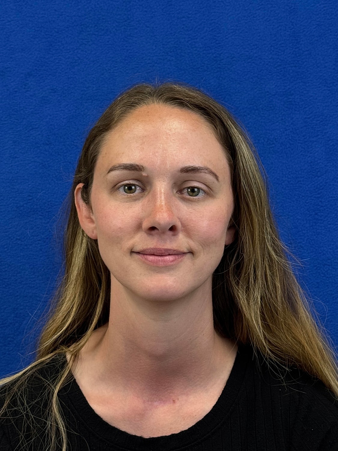 Woman with long hair in front of blue background.